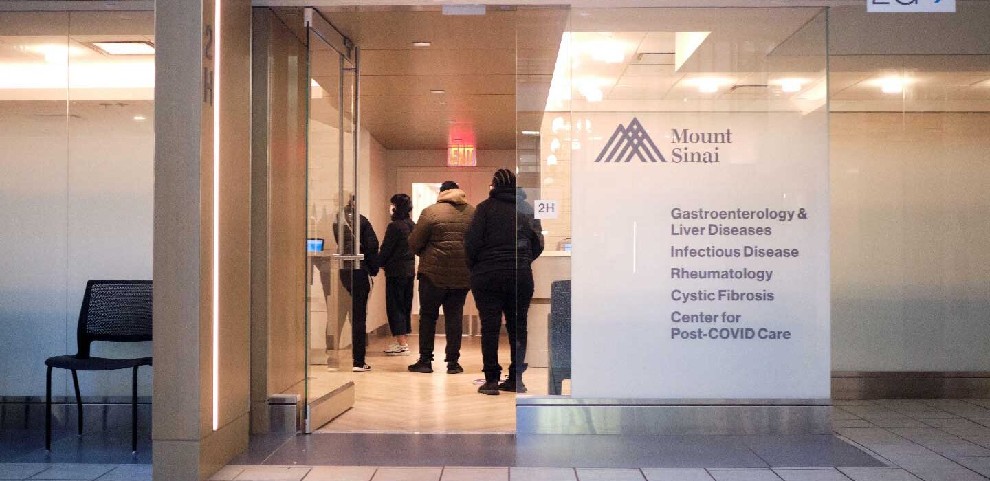 Four patients line up at a desk in Mount Sinai's Center for Post-COVID Care